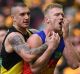 Brisbane's Nick Robertson clutches his face after an incident involving Richmond's Dustin Martin.