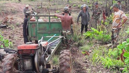 Local Phan Sina (centre right) on Friday confronts soldiers she accuses of attempting to steal land she has cultivated for years. Adhoc