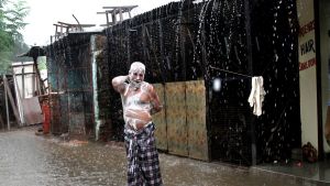 In this Tuesday, July 11, 2017 file photo, a man soaps himself up and takes bath during monsoon rains in Allahabad, ...