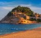 Fortress and fishing boats at Gran Platja beach and Badia de Tossa bay in the evening in Tossa de Mar on Costa Brava, ...