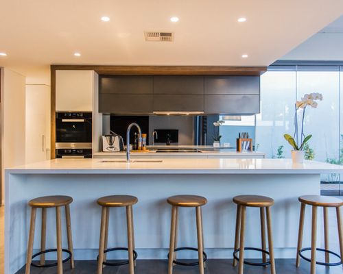 Contemporary kitchen idea in Perth with a double-bowl sink, flat-panel cabinets, black appliances and an island