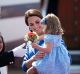 Britain's Kate, the Duchess of Cambridge holds her daughter Princess Charlotte as they arrive at the airport in Berlin, ...