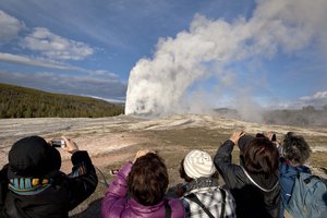 In this May 21, 2011 file photo, tourists photograph Old Faithful erupting, at Yellowstone National Park, in Mont