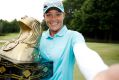 Katherine Kirk  imitates a "selfie" as she poses with the championship trophy after winning the Thornberry Creek LPGA ...