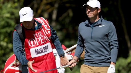 Rory McIlroy of Northern Ireland looks dejected as he hands the club to his caddie JP Fitzgerald.