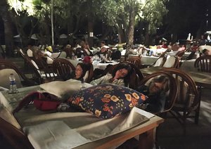 Hotel guests sleep outdoors after abandoning their rooms following an earthquake in Bitez, a resort town about 6 kilometers (4 miles) west of Bodrum, Turkey,  early Friday, July 21, 2017. A powerful earthquake struck Turkey's Aegean coast and nearby Greek islands, sending frightened residents running out of buildings they feared would collapse and into the streets. (AP Photo/Ayse Wieting)