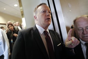 White House Press secretary Sean Spicer, center, notifies members of the media waiting in the White House Press Briefing Room in Washington that President Donald Trump will speak to them about the health care overhaul bill, Friday, March 24, 2017.