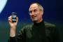 Former Apple chief executive Steve Jobs holds the first iPhone.