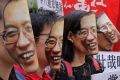 Protesters wear masks of Chinese Nobel Peace laureate Liu Xiaobo during a demonstration demanding his release outside ...