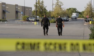 San Antonio police officers investigate the scene where eight people were found dead in a tractor-trailer loaded with at least 30 others outside a Walmart store in stifling summer heat in what police are calling a horrific human trafficking case, Sunday, July 23, 2017, in San Antonio.