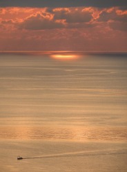 Paths of gold. A fishing Boat makes its way back to shore at sunrise. Koh Samui. Morning light shines through.