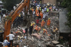 Rescuers work on the debris after a five-story building collapsed in the Ghatkopar area of Mumbai, India, Tuesday, July 25, 2017. A fire official says 11 people have been rescued and more are feared trapped.