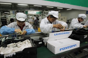 In this May 26, 2010 file photo, staff members work on the production line at the Foxconn complex in the southern Chinese city of Shenzhen, southern China