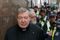 MELBOURNE, AUSTRALIA - JULY 26: Cardinal George Pell walks with a heavy Police guard from the Melbourne Magistrates' ...