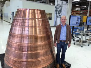 Amazon.com founder Jeff Bezos stands next to a copper exhaust nozzle to be used on a space ship engine during a media tour of Blue Origin, the space venture he founded, Tuesday, March 8, 2016, in Kent, Wash.