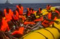 Migrants wait to be rescued by aid workers next to dead bodies of other migrants in the Mediterranean Sea, north of ...