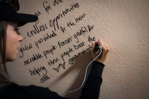 Jess Taylor, writes on the wall of The Gatwick at the open day on Saturday.