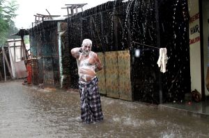 In this Tuesday, July 11, 2017 file photo, a man soaps himself up and takes bath during monsoon rains in Allahabad, ...