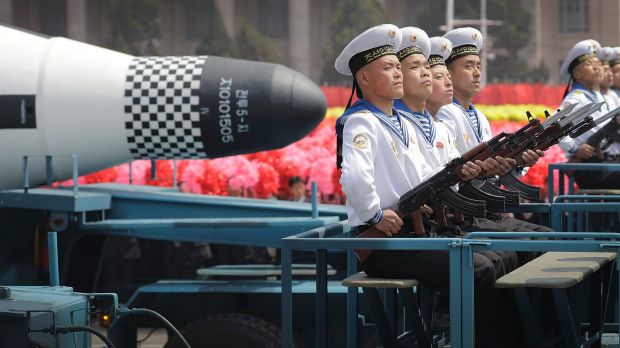 Navy personnel sit in front of a submarine-launched "Pukguksong" ballistic missile as it is paraded through Pyongyang, ...