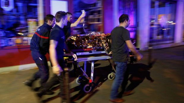 A person is being evacuated after a shooting, outside the Bataclan theater in Paris, in which 130 people died.