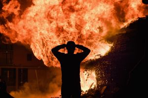 BELFAST, NORTHERN IRELAND - JULY 12: Loyalist are silhouetted as they gather in front of the bonfire on the Sandy Row ...