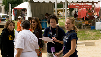 Interns Kathryn Young (right) and Sara Manco (center) chat before the Welsh hymn singing at the 2009 Smithsonian Folklife Festival.