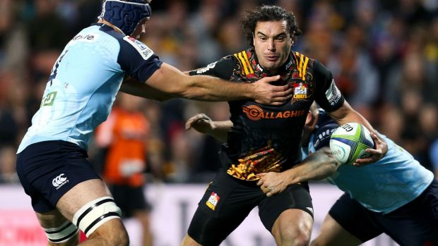 Getting away: James Lowe of the Chiefs offloads in the tackle of Tom Robertson and Dean Mumm.