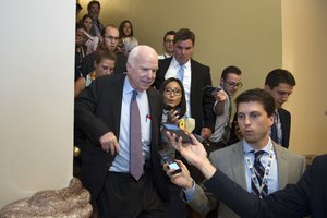 Sen. John McCain, R-Az., front left, is pursued by reporters after casting a 'no' vote on a a measure to repeal parts of former President Barack Obama's health care law, on Capitol Hill in Washington, Friday, July 28, 2017.