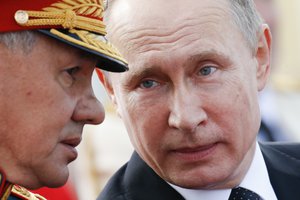 Russian President Vladimir Putin chats with Defence Minister Sergei Shoigu as they attend the military parade during the Navy Day celebration in St.Petersburg, Russia, on Sunday, July 30, 2017.