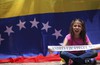 A girl holds a strip of paper with the name of a dead demonstrator that was killed in the protests against the government of President Nicolas Maduro, during a memorial at the Ninos Heroes monument in Mexico City, Sunday, July 30, 2017.