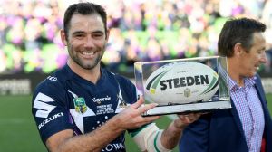 Milestone: Cam Smith holds his award after game 350, with coach Craig Bellamy in the background.