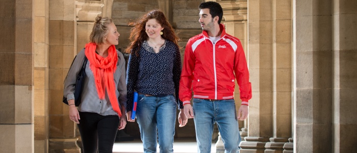 three students walking through the cloisters