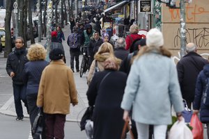 In this March 18, 2016 photo people walk on the sidewalk of a street in the borough Kreuzberg in Berlin, Germany