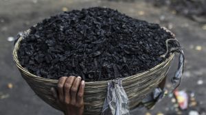 A worker carries a basket of coal on his head at a coal wholesale market in Mumbai, India, on Thursday, May 12, 2016. ...