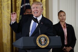 Capitol Hill police officers David Bailey, left, and Crystal Griner listen as President Donald Trump speaks in the East Room of the White House in Washington, Thursday, July 27, 2017,