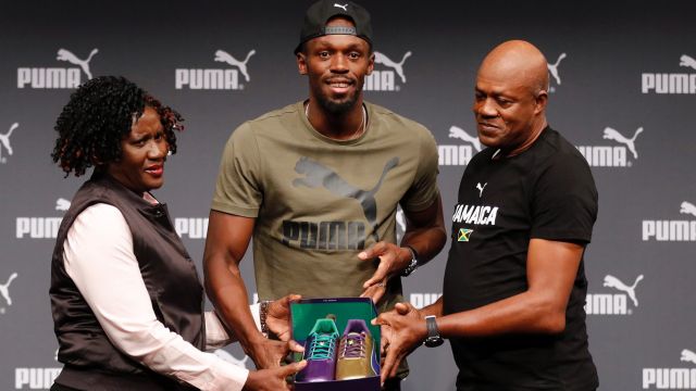 Usain Bolt with his parents, Jennifer and Wellesley, and the purple and gold shoes he will run in at the world titles.