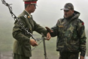 FILE - In this July 5, 2006 file photo, a Chinese soldier, left, and an Indian soldier put into place a barbed wire fence removed temporarily for Chinese officials to cross back to their country after a meeting with their Indian counterparts at the international border