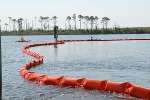 NAVAL AIR STATION PENSACOLA, Fla. - Kayakers at Naval Air Station Pensacola detour around an oil containment boom at Sherman Cove aboard the base, May 4, 2010. The boom was set to protect environmentally sensitive grass beds from the Deepwater Horizon oil spill. Deepwater Horizon was an ultra-deepwater oil rig that sank April 22, causing a massive oil spill threatening the U.S. Gulf Coast. U.S. Navy photo by Patrick Nichols. (850126) ( Pollution Response unit deploys containment boom )