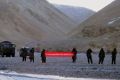 Chinese troops hold a banner reading "You've crossed the border, please go back" in Ladakh, India. 