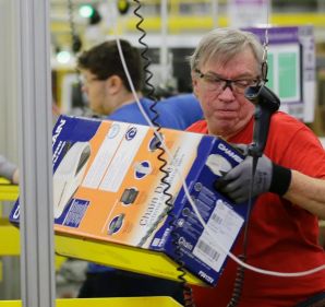 FILE - In this Monday, Nov. 30, 2015, file photo, Mark Oldenburg processes outgoing orders at Amazon.com's fulfillment ...