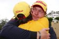 Golfer Jarrod Lyle hugs his wife Briony, after playing the Australian Masters in 2013, his return to golf after beating ...