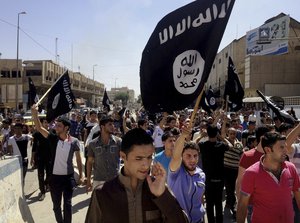 FILE - In this June 16, 2014 file photo, demonstrators chant pro-Islamic State group, slogans as they carry the group's flags in front of the provincial government headquarters in Mosul, 225 miles (360 kilometers) northwest of Baghdad.