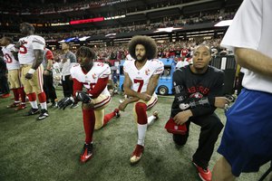 San Francisco 49ers quarterback Colin Kaepernick (7) and San Francisco 49ers outside linebacker Eli Harold (58) kneel during the playing of the National anthem before the first half of an NFL football game between the Atlanta Falcons and the San Francisco 49ers, Sunday, Dec. 18, 2016, in Atlanta.