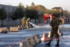 An Afghan soldier inspects the site of suicide attack In Kabul near Afghanistan's Defense Ministry, Monday, Sept. 5, 2016. Twin bombings near the Afghan Defense Ministry have killed dozens of people in an attack claimed by the Taliban.