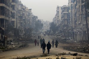 Residents walk through the destruction of the once rebel-held Salaheddine neighborhood in the eastern Aleppo, Syria