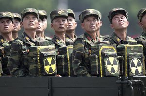 In this July 27, 2013, file photo, North Korean soldiers turn and look towards their leader Kim Jong Un as they carry packs marked with the nuclear symbol as they parade during a ceremony marking the 60th anniversary of the Korean War armistice in Pyongyang, North Korea.