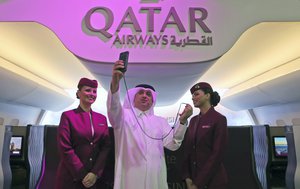 A Qatari man takes a selfie in front of a mock-up of Qatar Airway's new Q Suite, during the Arabian Travel Market Exhibition in Dubai, United Arab Emirates, Monday, April 24, 2017.