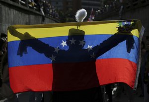 A demonstrator dressed as Venezuelan independence hero Simon Bolivar waves a national flag during a tribute to those killed during protests against Venezuela's President Nicolas Maduro, in Caracas, Venezuela, Monday, July 24, 2017.