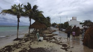 People walk along the waterfront after the passage of Tropical Storm Franklin in Mahahual, Quintana Roo state, Mexico, Tuesday, Aug. 8, 2017. Residents said the beach had shrunk by several meters the morning after the storm struck. A weakened Tropical Storm Franklin chugged across Mexico's Yucatan Peninsula Tuesday, dumping heavy rain after coming ashore on the Caribbean coast.(AP Photo/Israel Leal)