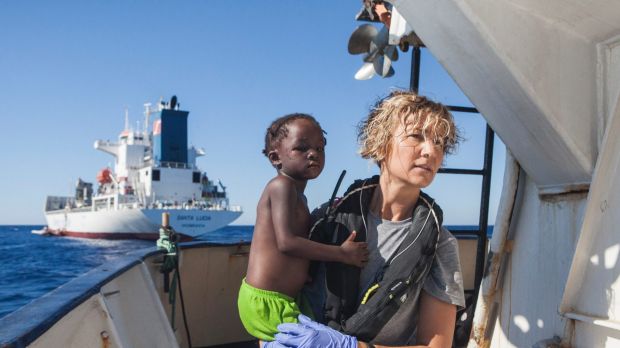 A Spanish nurse of Proactiva Open Arms NGO carries a child rescued from the Mediterranean Sea aboard the Golfo Azzurro ...